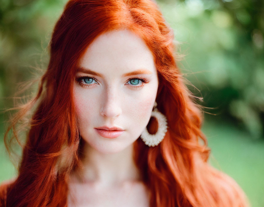 Vibrant red-haired woman with blue eyes against green backdrop