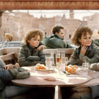 Four people at outdoor café with city street background