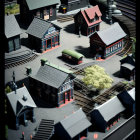 Detailed miniature train station model with tracks, buildings, and trains under dramatic lighting