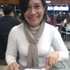 Smiling woman in white blouse with cocktail at bar