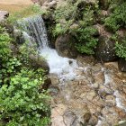 Miniature fantasy landscape with waterfall, church, greenery, and castle.