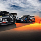 Two Racing Cars Emitting Flames Under Dramatic Sky