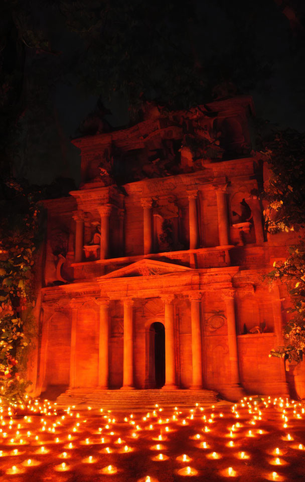 Ancient rock-cut architecture illuminated by candles at night