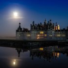 Mystical castle on hill with illuminated windows at night