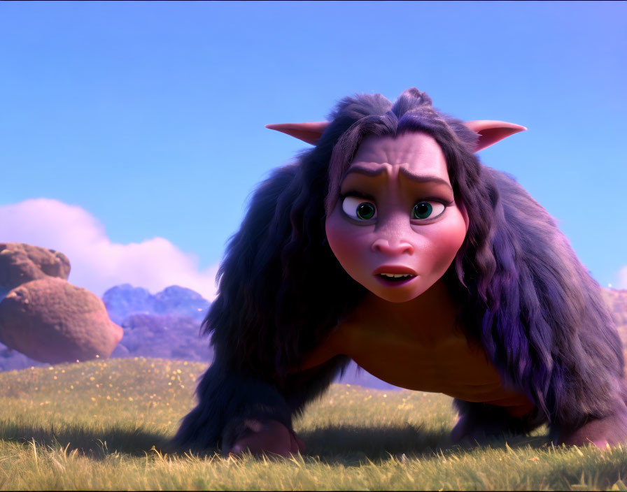 Long-haired creature with small horns crouching on grassy field gazes forward.