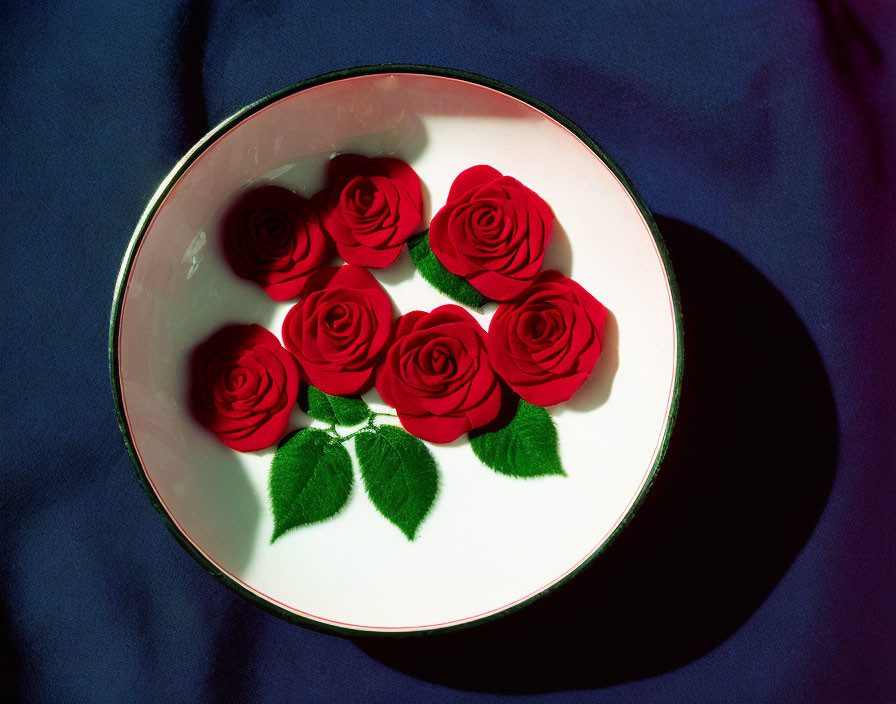 White Plate with Red Roses and Green Leaves on Dark Blue Background