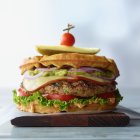 Classic Cheeseburger with Fresh Ingredients on Wooden Board