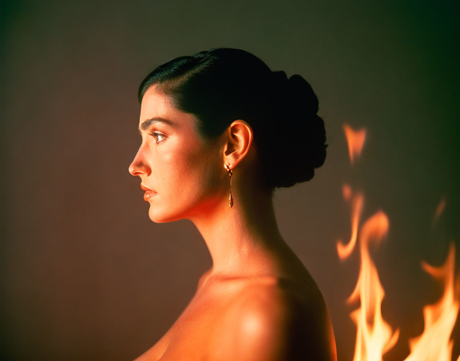 Profile of Woman with Bare Shoulder Next to Soft Flame on Muted Background