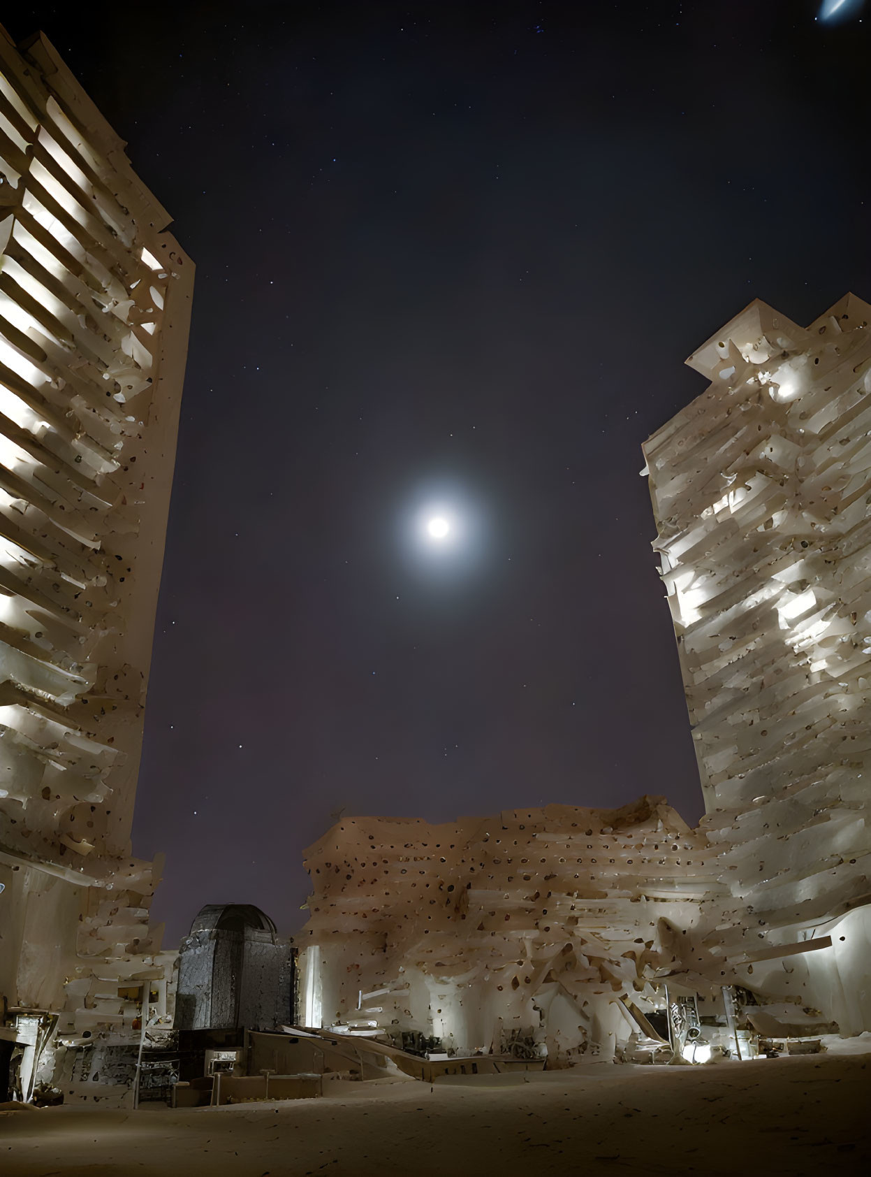 Urban night scene with bright moon between high-rise buildings under starry sky