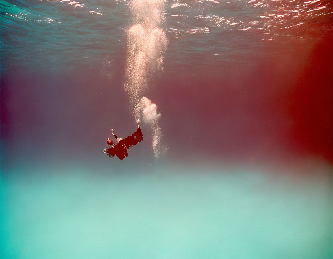 Underwater Diver Surrounded by Clear Blue Water and Rising Bubbles