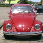 Digitally altered image: Red Volkswagen Beetle with oversized mechanical insects.