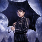 Stylized portrait of person with short hair holding black umbrella against cosmic background