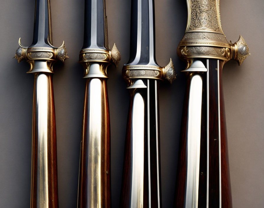 Four ornate ceremonial swords with detailed hilts and shiny blades on dark background