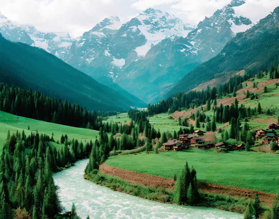 Scenic Green Valley with River, Houses, & Snowy Mountains