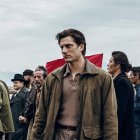 Group of stylish men in leather jackets with confident young man against cloudy sky