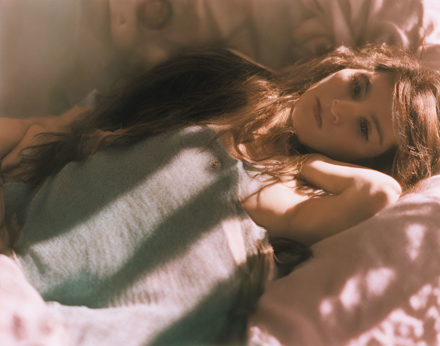 Long-Haired Person Lying Down in Soft Light: Serene and Contemplative Atmosphere