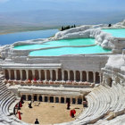 Ancient amphitheater watercolor painting with visitors and hills.