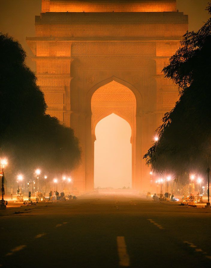 Historic illuminated archway at night under hazy sky