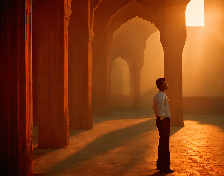 Man in Historical Building Bathed in Golden Sunlight