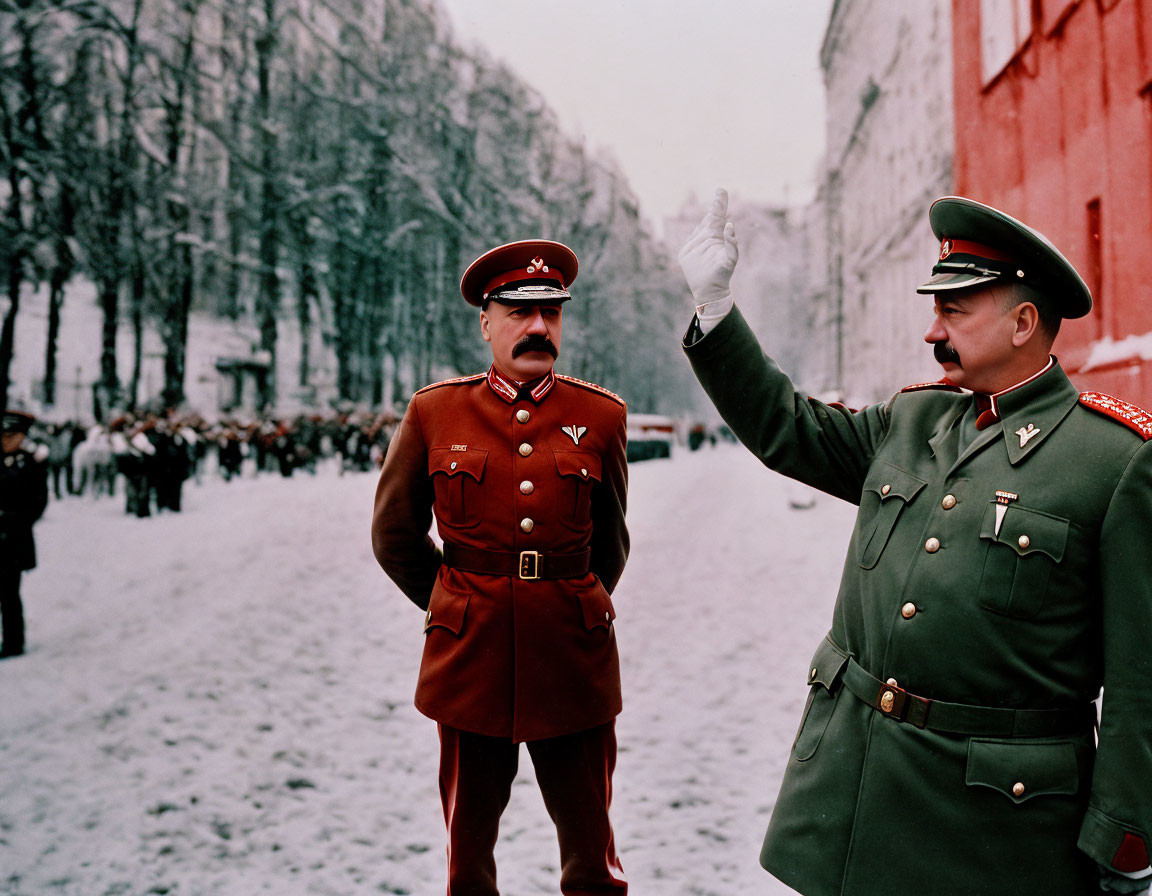 Military officers in red uniforms salute on snowy street with troops in background