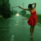 Woman in Red Dress with Blue Hair Holding Staff in Rainforest Stream