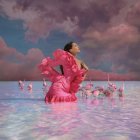 Dark-haired woman in vibrant pink gown by serene waterway in colorful nature scene