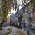 Stone Cottage Surrounded by Autumn Leaves and Ivy-Covered Archway