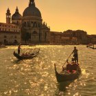 Sailboats on golden sea near castle at sunset