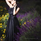 Woman in Purple Floral Dress Poses in Mystical Forest Setting