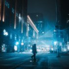 Futuristic cityscape at night with neon lights, wet streets, and skyscrapers