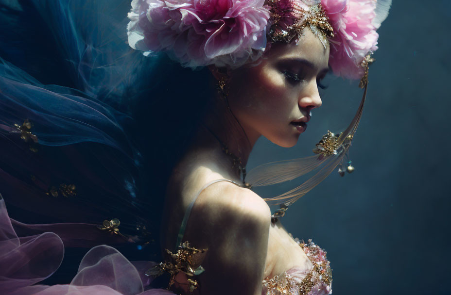 Ethereal woman with pink flowers and golden accessories in blue fabric.