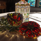 Vivid stained glass artwork and flowers on wooden table with sunlit window