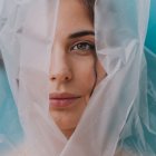 Portrait of a Woman with Striking Green Eyes and Translucent Plastic Sheet