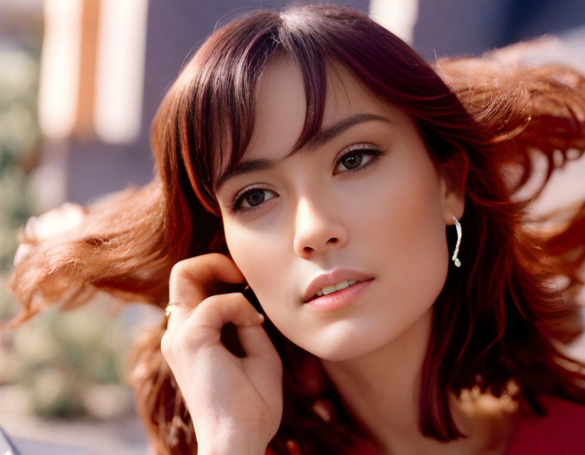 Portrait of woman with chestnut hair and light makeup gazes thoughtfully.