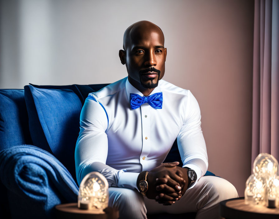 Man in White Shirt and Blue Bow Tie Sitting on Blue Sofa