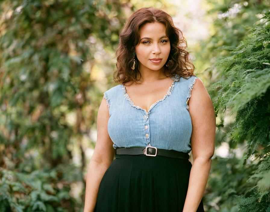 Woman with Wavy Hair in Blue Blouse and Black Skirt Smiling Outdoors