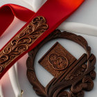 Intricate bronze medal with red ribbon on white surface