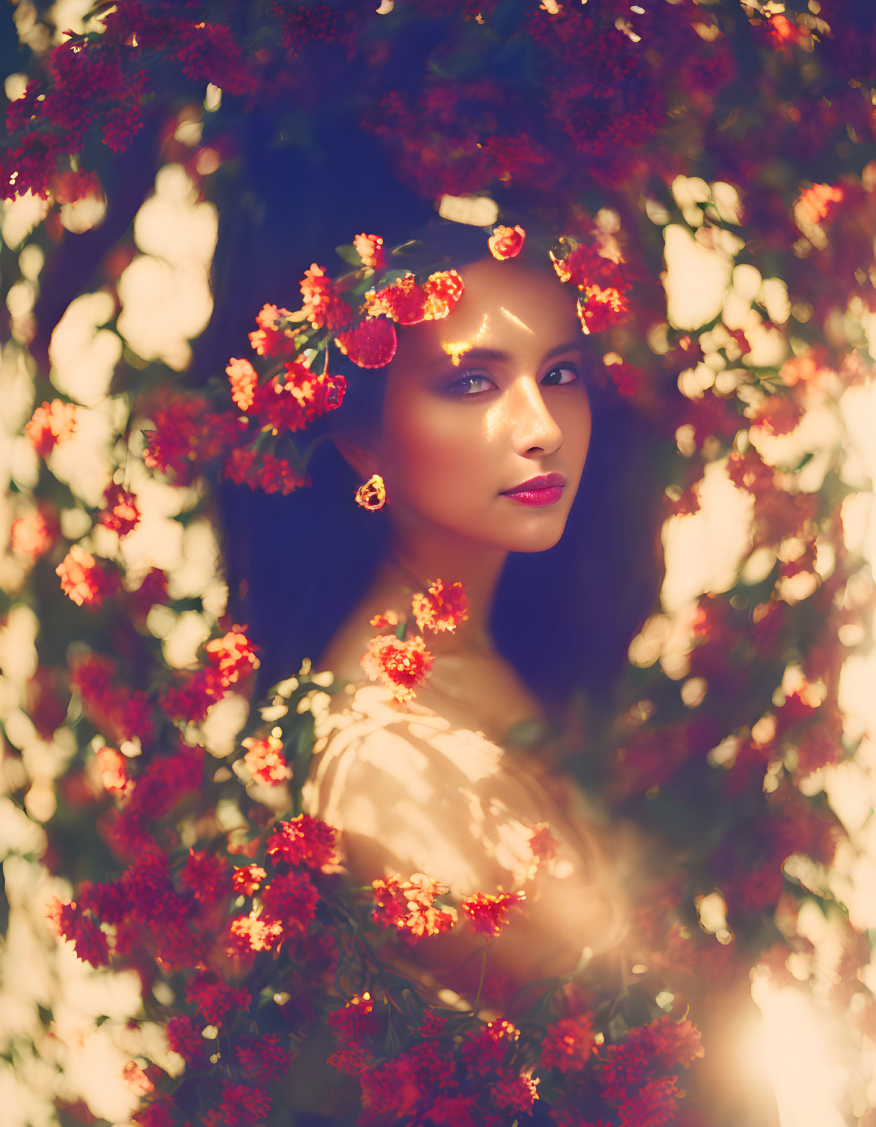 Woman surrounded by vibrant flowers and leaves in sunlight glow