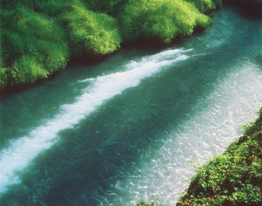 Tranquil River Flowing Through Lush Green Grass