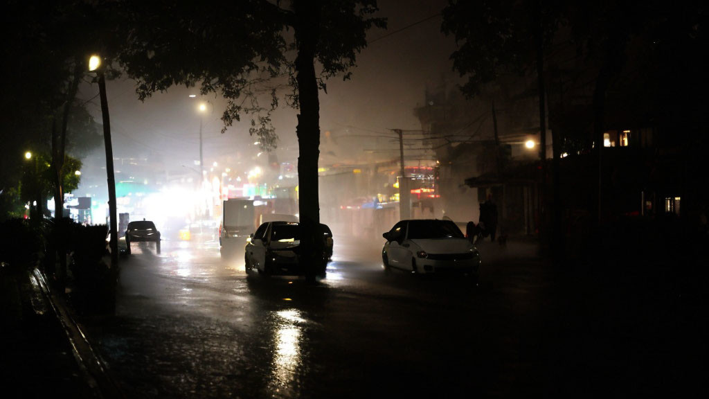 Urban Night Scene: Dimly-Lit Street with Cars and Fog