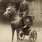 Stylized figure in teal top hat and goggles on horse-drawn chariot with golden designs on