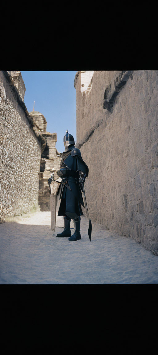 Medieval knight in armor with sword and shield in castle passageway