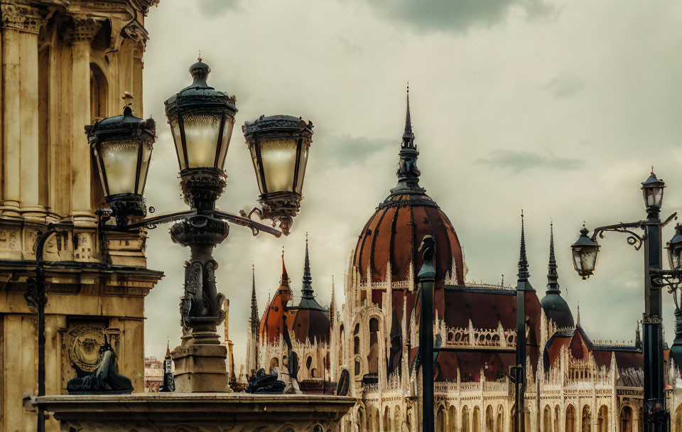 Gothic-style building with vintage street lamps under cloudy sky