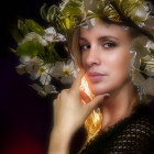 Woman with Floral Hair Accessories and Green Eyeshadow on Warm Background