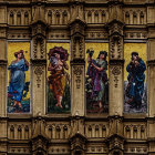 Ornate sculpture of three winged figures in blue and purple floral setting