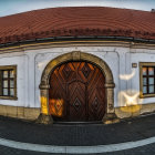 Historic curved building with grand door and orange roof in warm sunset light