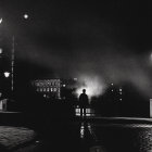 Snowy Evening Scene: People Walking Near Lit Street Lamps