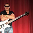 Man Playing Electric Guitar with Wet Hair in Water Splash on Red Background