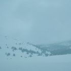 Snow-Covered Peaks Under Clear Blue Sky with Solitary Cloud