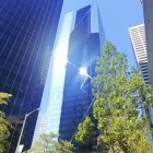 Urban park with skyscrapers, green building, and people walking